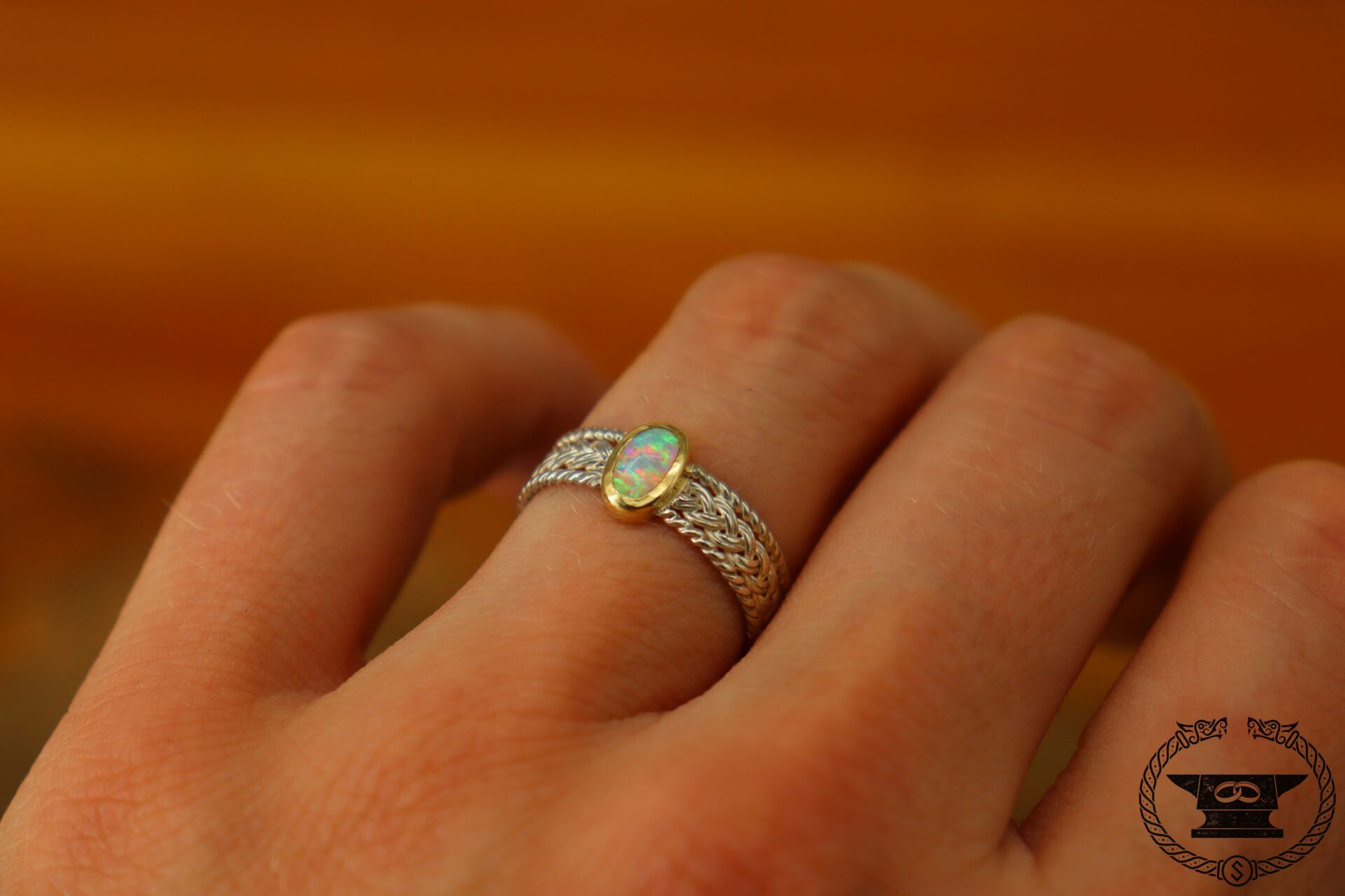 Finely braided ring made of sterling silver and 585 yellow gold with opal drop.
